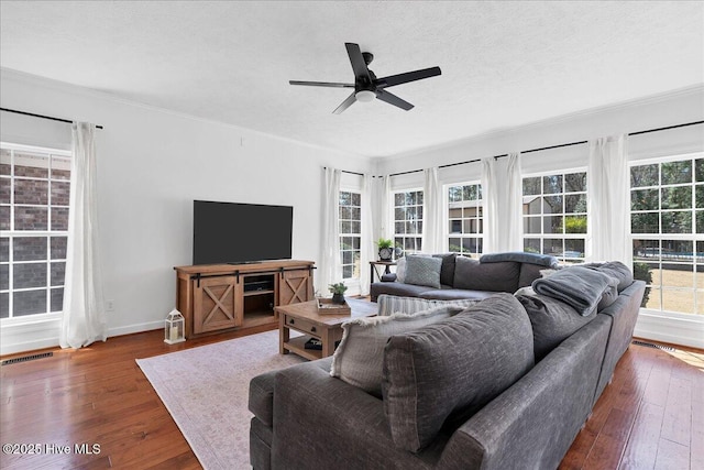 living room featuring visible vents, ornamental molding, a textured ceiling, wood-type flooring, and ceiling fan