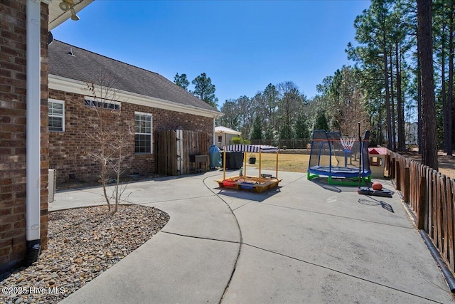 view of patio with a trampoline and a fenced backyard