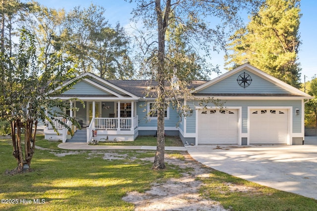 view of front of home with driveway, covered porch, an attached garage, and a front yard