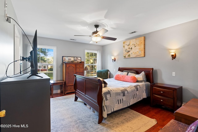 bedroom featuring ceiling fan, wood finished floors, and visible vents