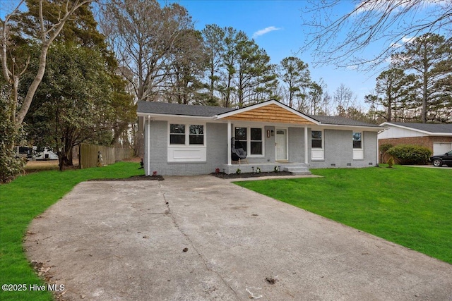 view of front of house with brick siding, crawl space, a front lawn, and fence