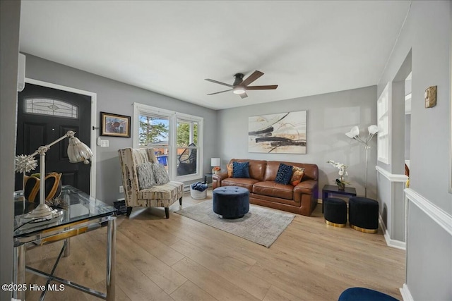 living area with a ceiling fan and wood finished floors