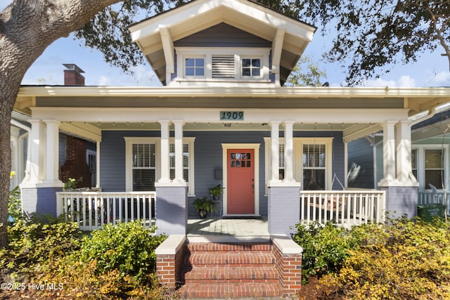 view of front of house featuring brick siding and a porch