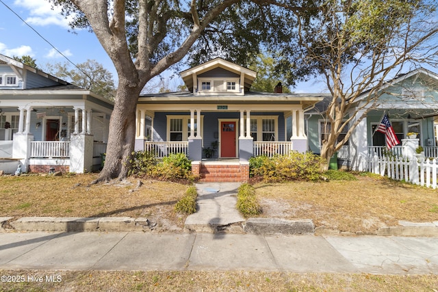 view of front of home with covered porch and fence