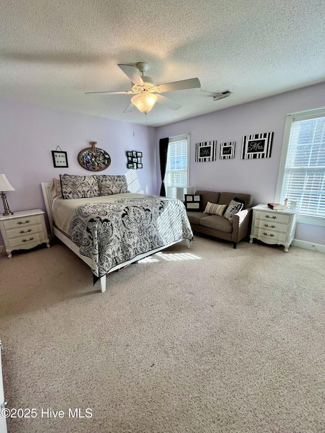 bedroom featuring ceiling fan, a textured ceiling, carpet, and visible vents