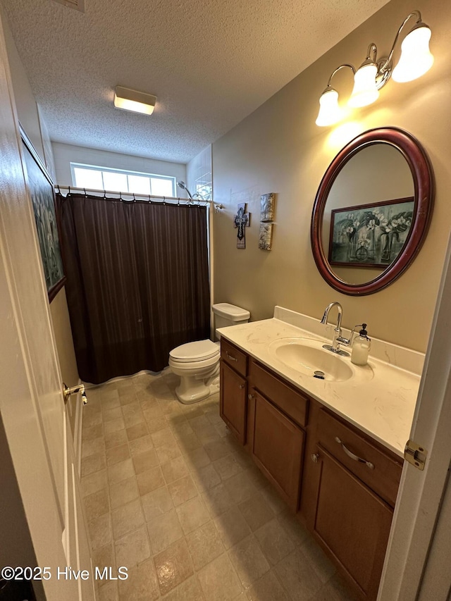 full bath featuring toilet, curtained shower, a textured ceiling, and vanity