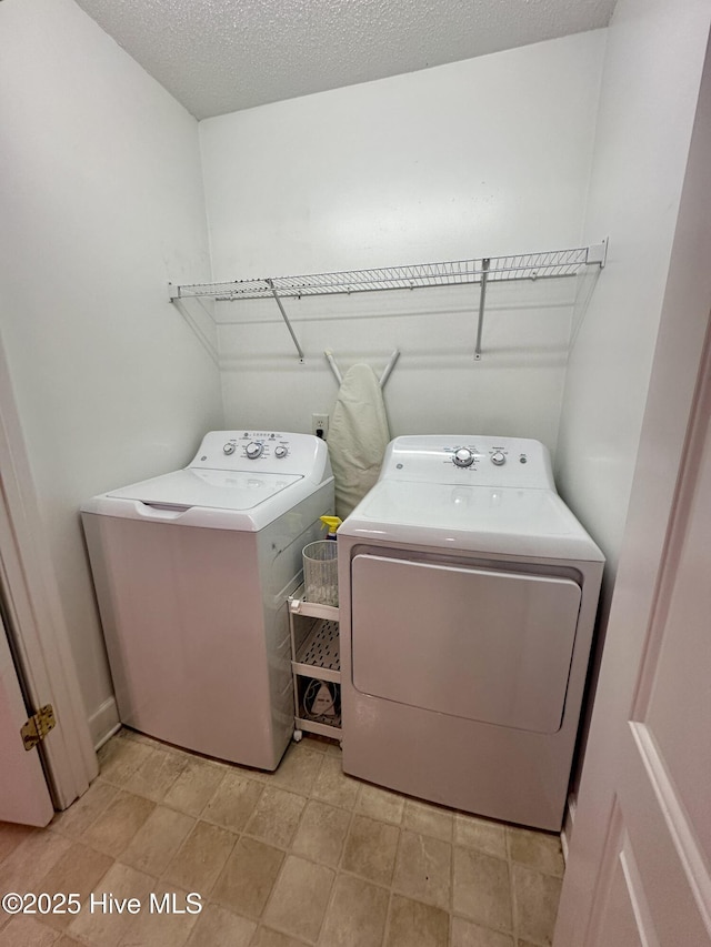 laundry room featuring laundry area, washer and clothes dryer, and a textured ceiling