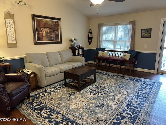 living area featuring vaulted ceiling, wood finished floors, a ceiling fan, and baseboards