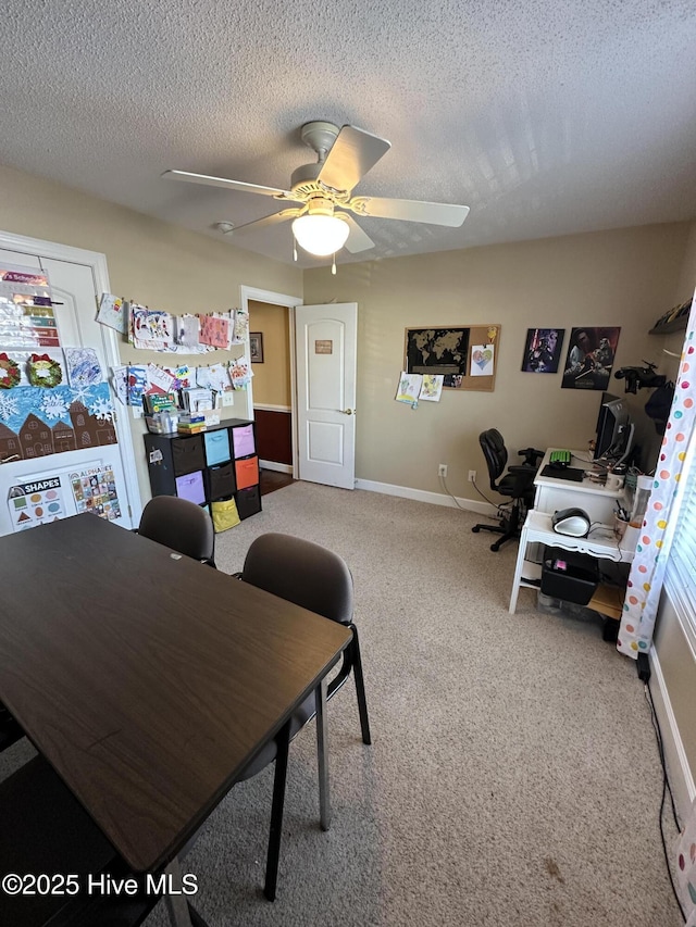 office area with a ceiling fan, carpet, a textured ceiling, and baseboards