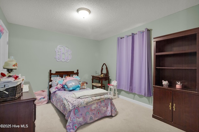 carpeted bedroom with baseboards and a textured ceiling