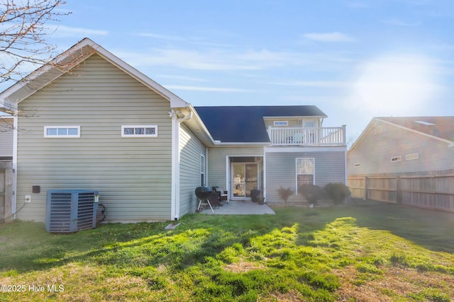 back of property featuring a balcony, central AC, fence, a lawn, and a patio area