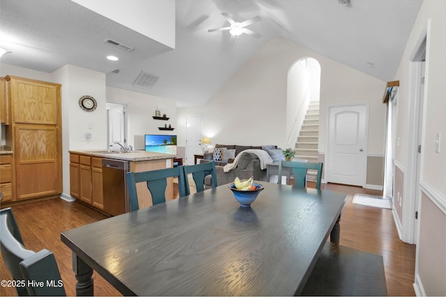 dining room featuring vaulted ceiling, visible vents, and dark wood finished floors