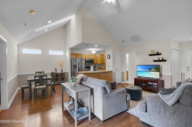 living area with high vaulted ceiling, recessed lighting, visible vents, and dark wood finished floors