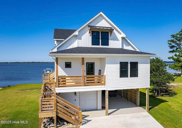 view of front of house featuring a shingled roof, a front lawn, stairway, driveway, and an attached garage