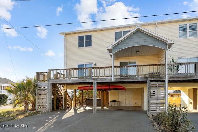 view of front of home featuring driveway, stairs, a porch, and a carport