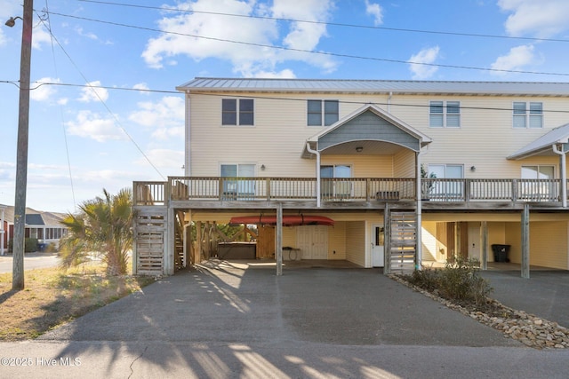 view of front of house featuring stairs, metal roof, and aphalt driveway