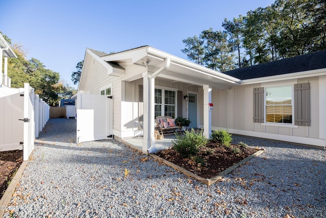 view of front of home featuring board and batten siding, fence, and a gate