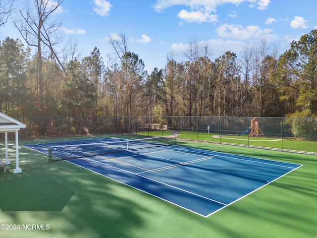 view of sport court featuring playground community and fence