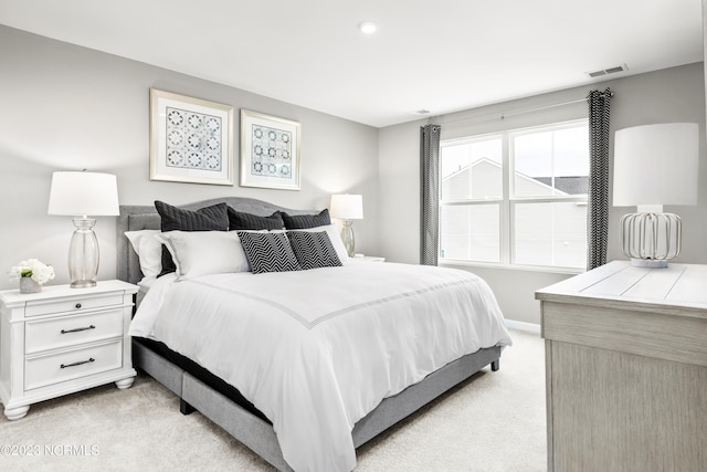 bedroom featuring baseboards, visible vents, and light colored carpet