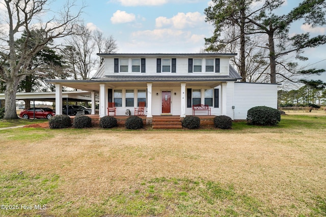 view of front of home featuring covered porch, metal roof, a front lawn, and an attached carport