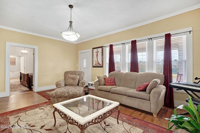 living room featuring crown molding, baseboards, and wood finished floors