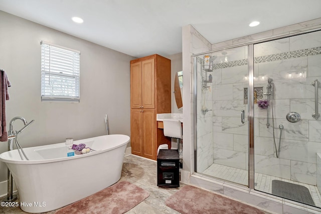 full bathroom with a stall shower, a freestanding tub, and recessed lighting