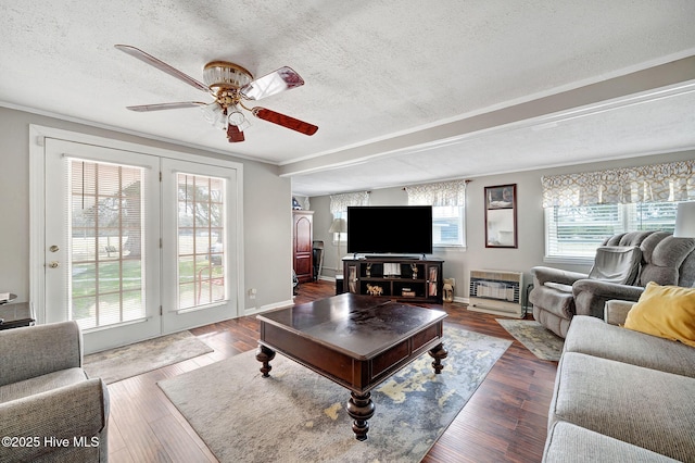 living room featuring heating unit, a textured ceiling, a ceiling fan, and hardwood / wood-style floors