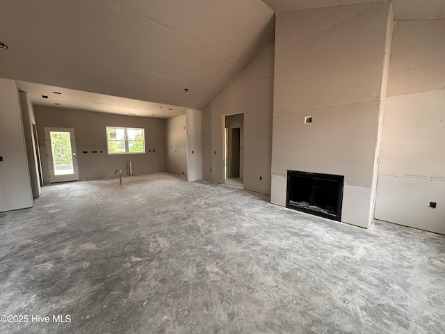 unfurnished living room featuring high vaulted ceiling and a fireplace