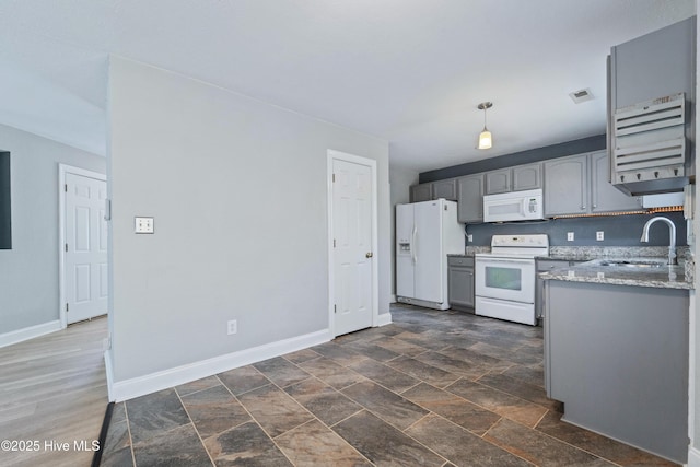 kitchen featuring white appliances, baseboards, visible vents, gray cabinets, and a sink