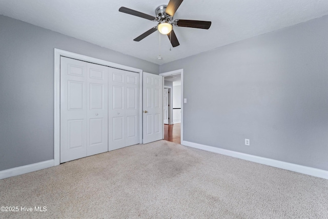 unfurnished bedroom with carpet floors, a closet, and baseboards