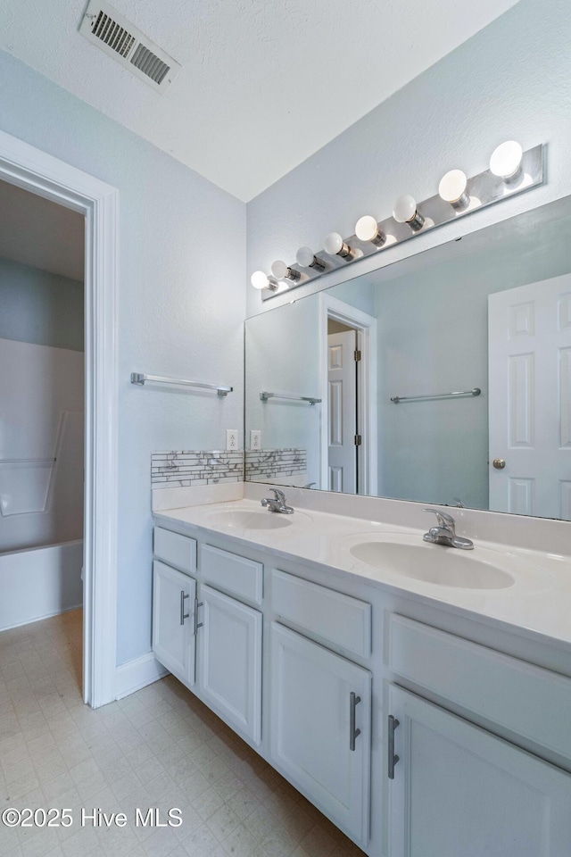 full bath with tile patterned floors, visible vents, a sink, and double vanity