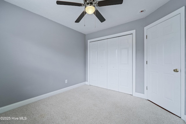 unfurnished bedroom with ceiling fan, carpet floors, a closet, and baseboards