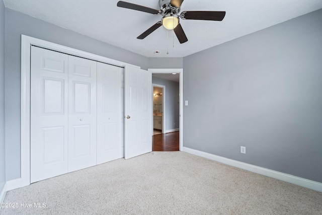 unfurnished bedroom featuring a ceiling fan, carpet, a closet, and baseboards