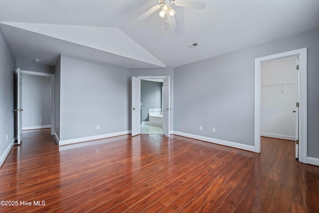 unfurnished bedroom with lofted ceiling, wood finished floors, and baseboards