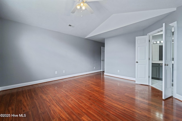 spare room with visible vents, vaulted ceiling, baseboards, and wood finished floors