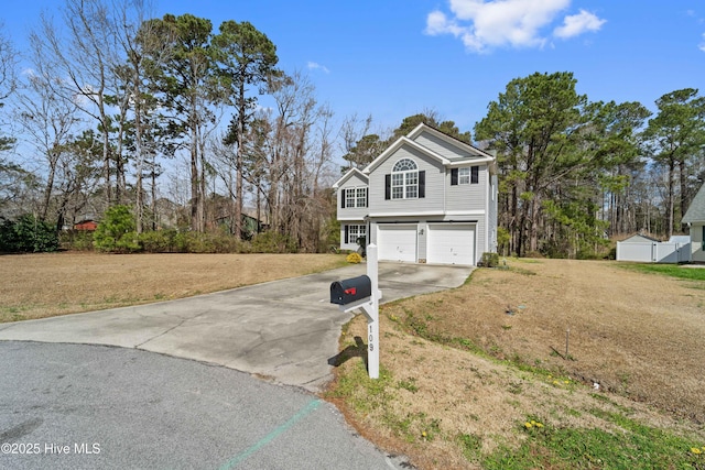 view of front of house featuring a front yard, driveway, and an attached garage