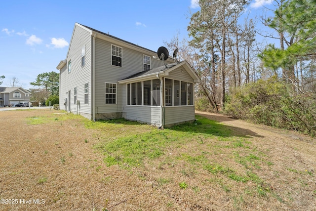 back of house featuring a sunroom and a yard