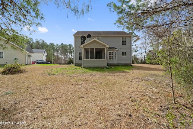 back of property with a sunroom and a yard