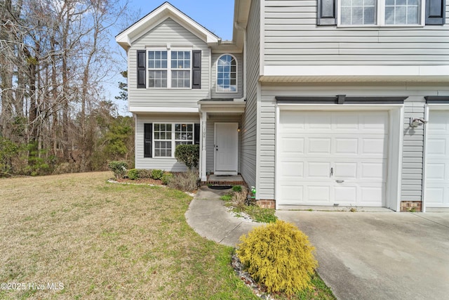 traditional-style home with a garage, driveway, and a front yard