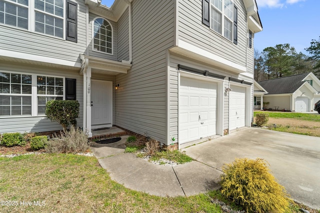 view of exterior entry featuring driveway and an attached garage