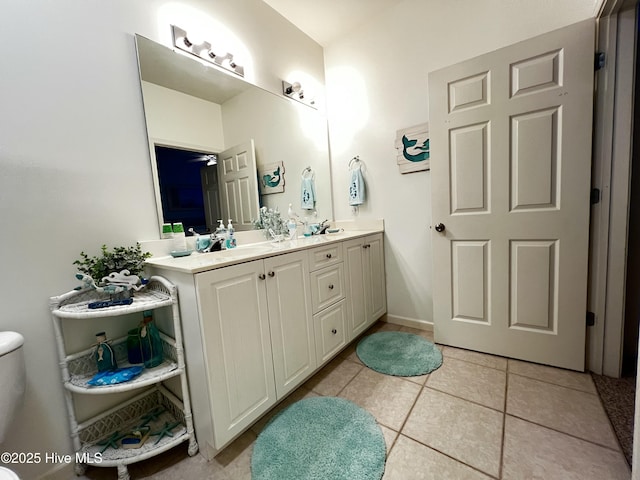 bathroom with double vanity, tile patterned flooring, and toilet