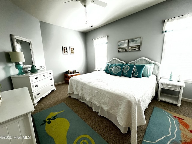 bedroom with dark colored carpet, ceiling fan, and baseboards