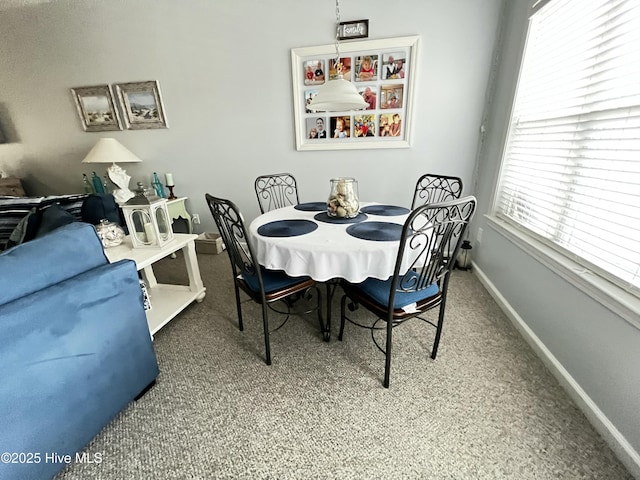 dining area featuring carpet flooring and baseboards