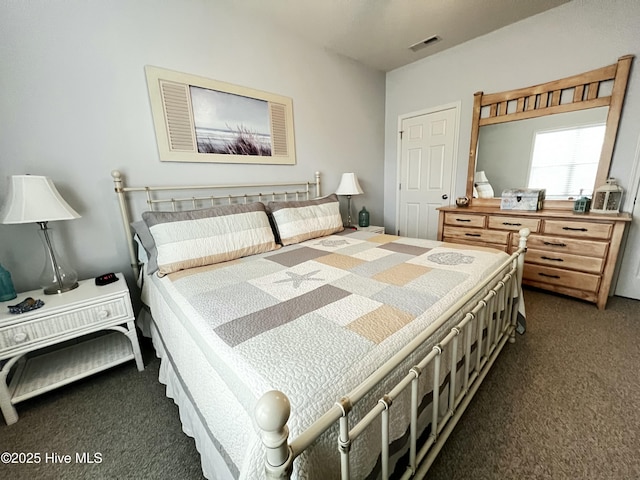 bedroom with visible vents and dark carpet