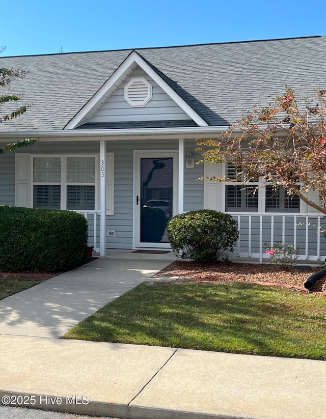 doorway to property featuring a shingled roof and covered porch