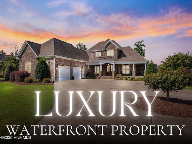 view of front of property with driveway, an attached garage, a yard, and roof with shingles