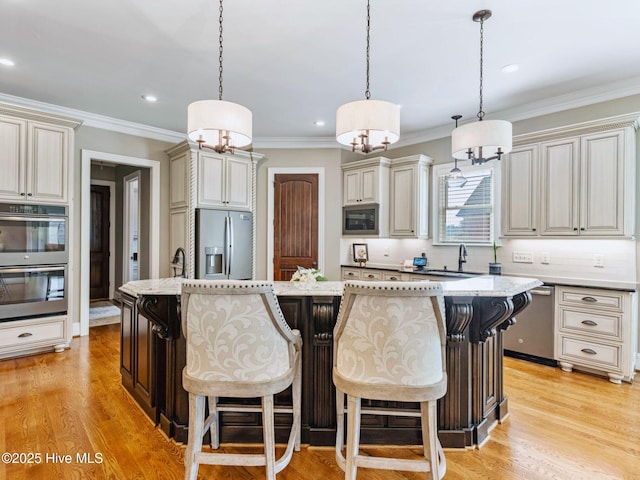 kitchen featuring light wood-style floors, cream cabinets, and appliances with stainless steel finishes