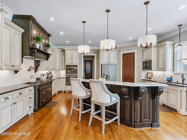 kitchen featuring ornamental molding, a kitchen breakfast bar, a center island, stainless steel appliances, and light wood-style floors