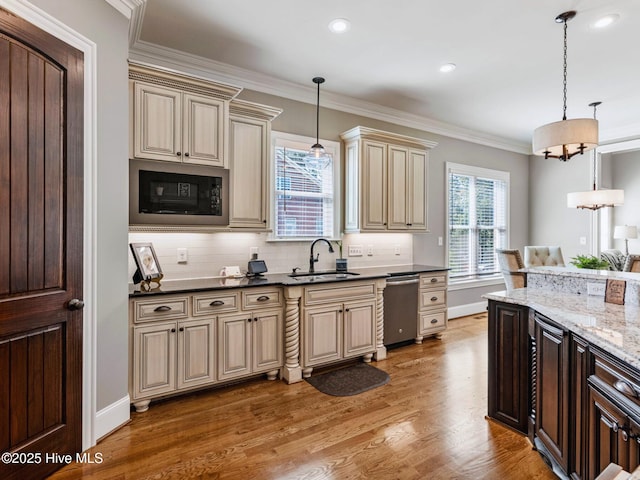 kitchen featuring light wood finished floors, crown molding, black microwave, cream cabinets, and a sink