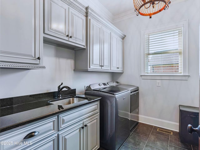 clothes washing area featuring visible vents, a sink, washer and dryer, cabinet space, and crown molding